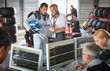 © Chris Ryan/Caia Image - Manager formula one driver discussing telemetry diagnostics in repair garage