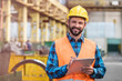 © Rafal Rodzoch/Caia Image - Portrait smiling steel worker with clipboard in factory