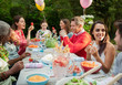 © Robert Daly/Caia Image - Family and friends enjoying birthday garden party at patio table