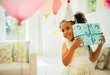 © Robert Daly/Caia Image - Curious girl shaking birthday gift