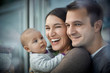 © Great Images/Caia Image - Smiling happy parents holding baby daughter