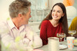 © Robert Daly/Caia Image - Smiling couple talking and drinking champagne at party table
