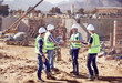 © Trevor Adeline/Caia Image - Construction workers engineers shaking hands, meeting sunny construction site