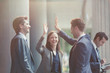 © Tom Merton/Caia Image - Business people high-fiving in office lobby