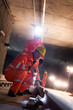 © Rafal Rodzoch/Caia Image - Male construction workers examining underground tracks at dark construction site