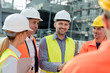 © Rafal Rodzoch/Caia Image - Smiling engineers construction workers meeting at construction site