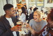 © Paul Bradbury/Caia Image - Laughing friends toasting beer and wine glasses at bar