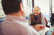 © Paul Bradbury/Caia Image - Senior couple talking and using smart phone in cafe
