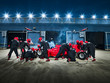 © Chris Ryan/Caia Image - Pit crew working on formula one race car in pit stop