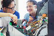 © Robert Daly/Caia Image - Smiling girl students assembling computer in classroom