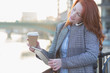 © Martin Barraud/Caia Image - Businesswoman multitasking, drinking coffee using digital table while talking on cell phone
