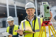 © Agnieszka Olek/Caia Image - Portrait smiling male engineer using theodolite at construction site