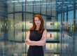© Martin Barraud/Caia Image - Portrait confident businesswoman with red hair in modern office atrium