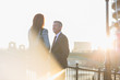 © Martin Barraud/Caia Image - Businessman and businesswoman talking at sunny urban railing