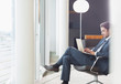 © Martin Barraud/Caia Image - Businessman using laptop in office lounge