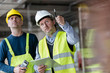 © Rafal Rodzoch/Caia Image - Male foreman engineer with clipboard looking up at construction site