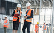 © Rafal Rodzoch/Caia Image - Engineers with clipboards meeting at construction site