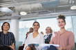 © Sam Edwards/Caia Image - Smiling, attentive businesswoman listening in conference audience