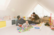 © Tom Merton/Caia Image - Male gay parents playing with baby sons in playroom