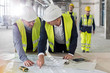 © Agnieszka Olek/Caia Image - Male engineers discussing blueprints at construction site