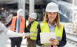 © Agnieszka Olek/Caia Image - Portrait smiling female engineer with clipboard at construction site