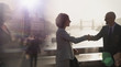 © Tom Merton/Caia Image - Silhouette business people handshaking on sunny bridge over River Thames, London, UK