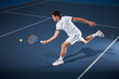 © Chris Ryan/Caia Image - Male tennis player playing tennis, reaching tennis racket on tennis court