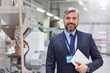 © Lukasz Olek/Caia Image - Portrait smiling, confident businessman digital tablet in fiber optics factory