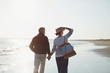 © Sam Edwards/Caia Image - Affectionate mature couple holding hands and walking on sunny beach