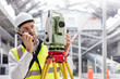 © Agnieszka Olek/Caia Image - Male engineer using walkie-talkie and theodolite at construction site