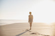 © Sam Edwards/Caia Image - Pensive, serene woman walking on sunny summer beach