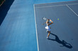 © Chris Ryan/Caia Image - Overhead view young female tennis player playing tennis on sunny blue tennis court