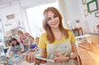 © Agnieszka Olek/Caia Image - Portrait confident female artist holding painted picture frame in art class workshop