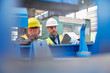 © Rafal Rodzoch/Caia Image - Male foreman and worker reviewing paperwork in factory