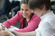 © Martin Barraud/Caia Image - Smiling students using digital tablet in classroom
