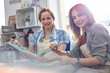 © Rafal Rodzoch/Caia Image - Portrait smiling female artists painting in art class workshop