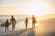 © Sam Edwards/Caia Image - Family surfers walking with surfboards on sunny summer sunset beach