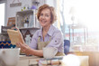 © Agnieszka Olek/Caia Image - Portrait smiling mature female artist painting wood in art class workshop