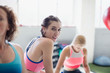 © Sam Edwards/Caia Image - Portrait smiling confident young woman working out in gym