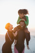 © Sam Edwards/Caia Image - Happy family in wet suits on summer sunset beach
