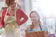 © Rafal Rodzoch/Caia Image - Female artists painting wood in art class workshop