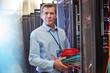 © Agnieszka Olek/Caia Image - Portrait serious male IT technician holding cables in server room