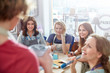 © Agnieszka Olek/Caia Image - Female art students listening to instructor in art painting class workshop