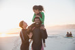 © Sam Edwards/Caia Image - Portrait playful family surfers in wet suits on summer sunset beach