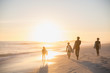 © Sam Edwards/Caia Image - Silhouette family surfers walking surfboards on idyllic, sunny summer sunset beach