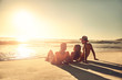 © Trevor Adeline/Caia Image - Young friends relaxing on idyllic, sunny summer sunset ocean beach