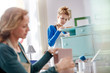 © Agnieszka Olek/Caia Image - Focused female artist painting side table blue in art class workshop