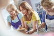 © Agnieszka Olek/Caia Image - Female artists painting picture frames in art class workshop