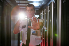 Portrait Male Security Guard Flashlight Gesturing Stop In Server Room