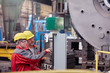 © Lukasz Olek/Caia Image - Male workers operating machinery at control panel in factory